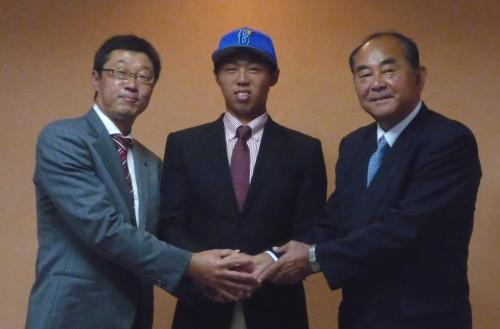 吉田スカウト部長（右）、河原スカウト（左）と握手を交わす平成国際大・狩野