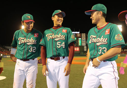 １４年８月３０日、史上初となるプロ初登板での１球勝利投手となり、枡田慎太郎内野手（左）と銀次内野手（右）に祝福され、笑顔を見せる横山貴明
