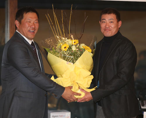 表彰式で山崎武司氏（左）から日米通算２０００本安打のお祝いの花束をもらう福留
