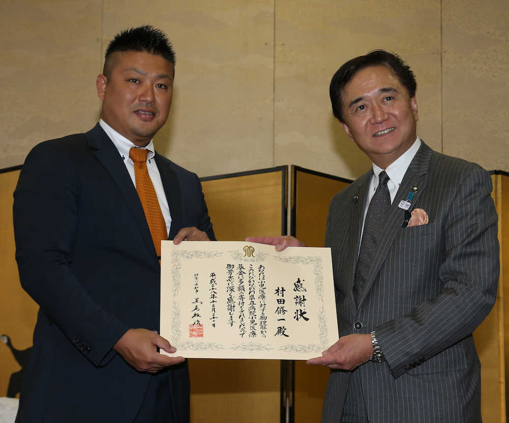 神奈川県の黒岩知事（右）から長年の社会貢献活動に対して感謝状を贈られる村田
