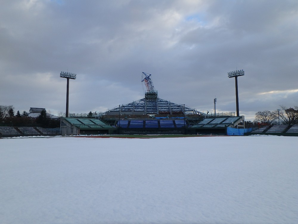 雪が積もる中、工事が進められている弘前市運動公園野球場（弘前市提供）