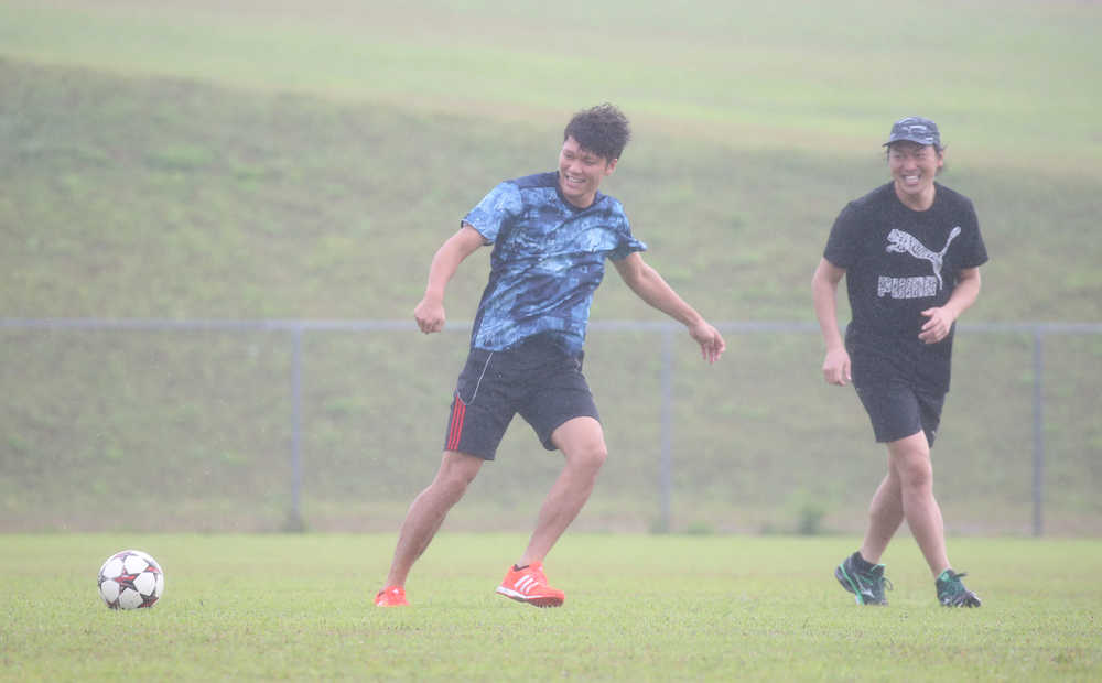 雨の中、サッカーをする（右から）長野、坂本