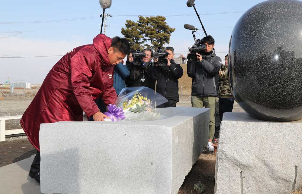 閖上地区の東日本大震災慰霊碑に花束を供える藤平