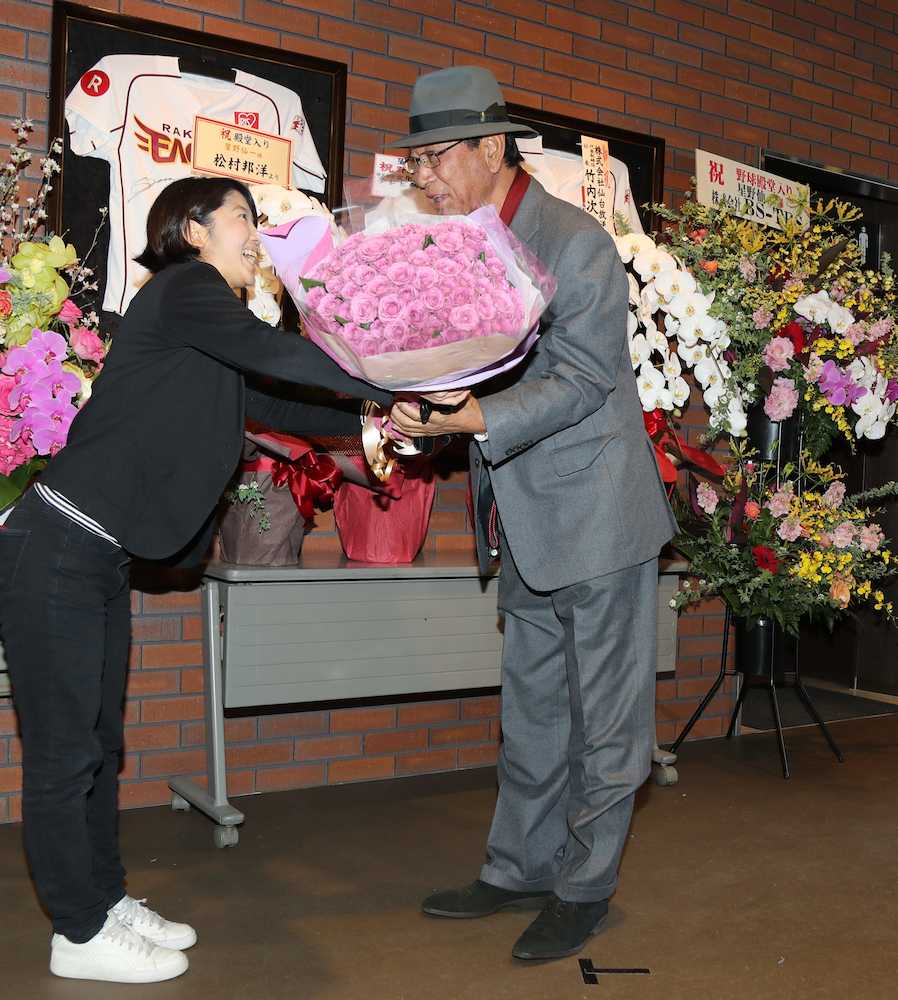 ２２日に７０歳の誕生日を迎える星野副会長（右）に報道陣から７０本の紫のバラが贈られる