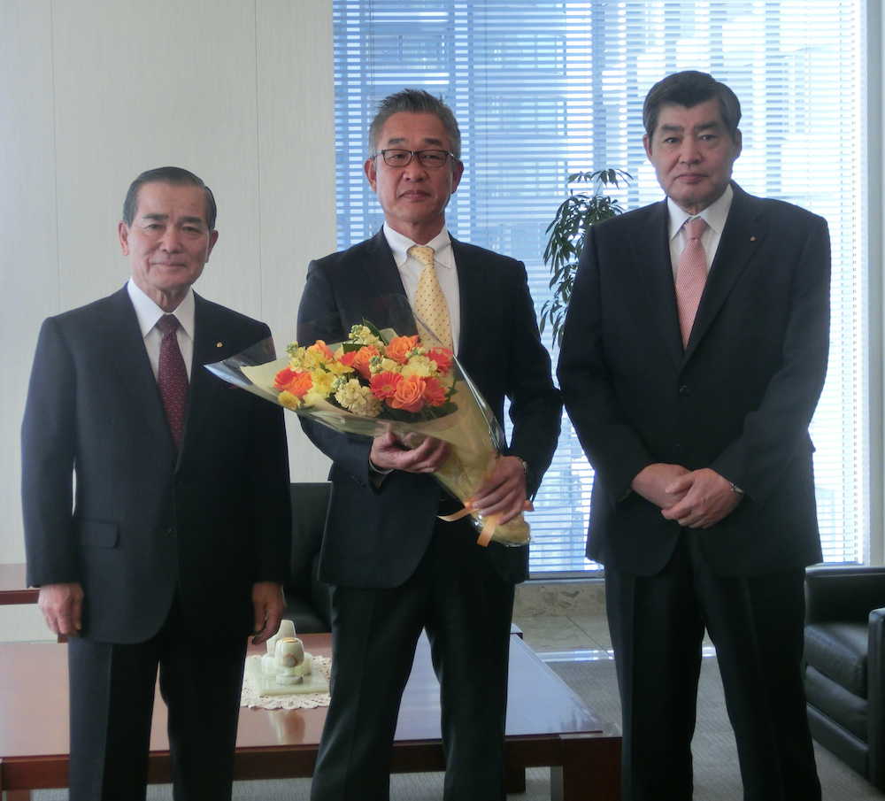 日本通運本社で花束を手に決意を新たにする辻監督（中央）。左は川合正矩代表取締役会長、右は渡辺健二代表取締役社長