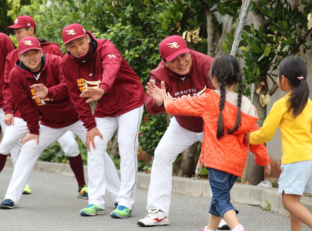 清水小学校で登校してくる児童たちにあいさつをしながらハイタッチで迎える（右から）梨田監督、藤平、池田