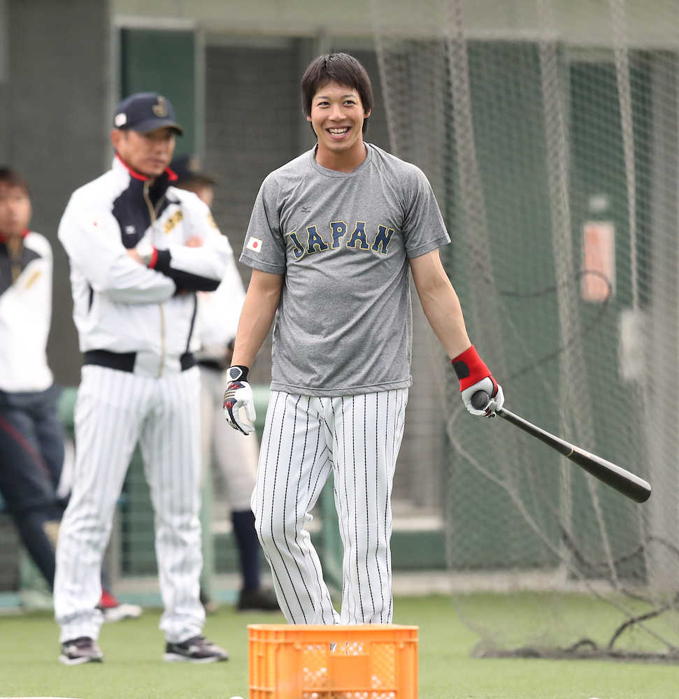 笑顔で打撃練習をする山田。左は小久保監督