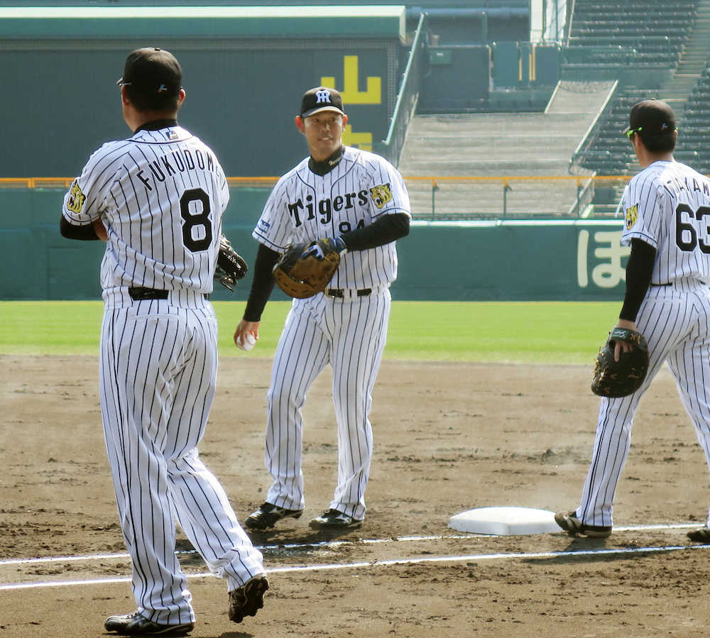 一塁の守備練習をする阪神・原口（中央）