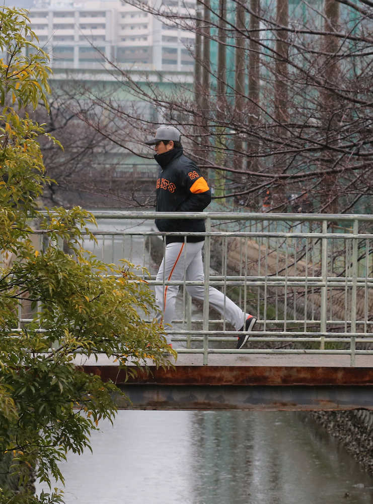 雨の中、足早に橋を渡って引き揚げる高橋監督