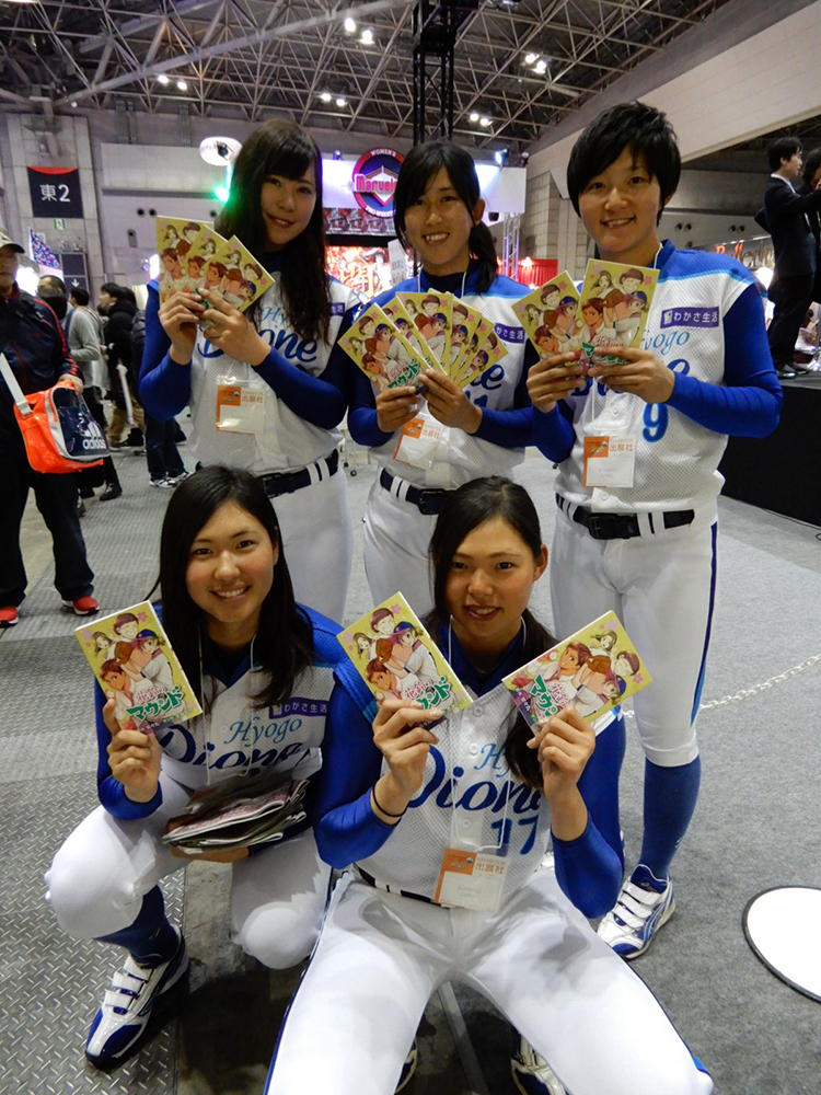 女子野球マンガ「花鈴のマウンド」特別版を配布する兵庫ディオーネの選手たち（前列左から古谷、泉、後列左からみなみ、坂東、三浦）