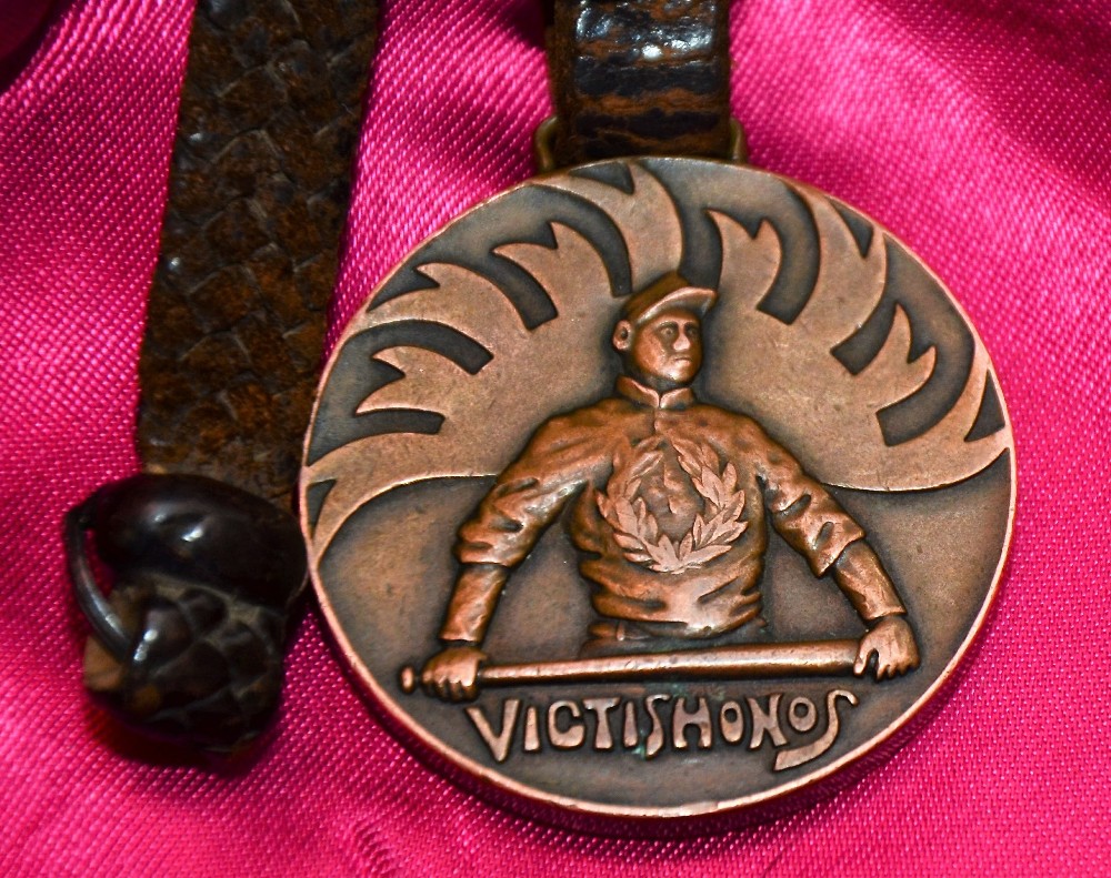 「ＶＩＣＴＩＳ　ＨＯＮＯＳ」（敗者に名誉を）の刻印がある第１回大会参加章のメダル