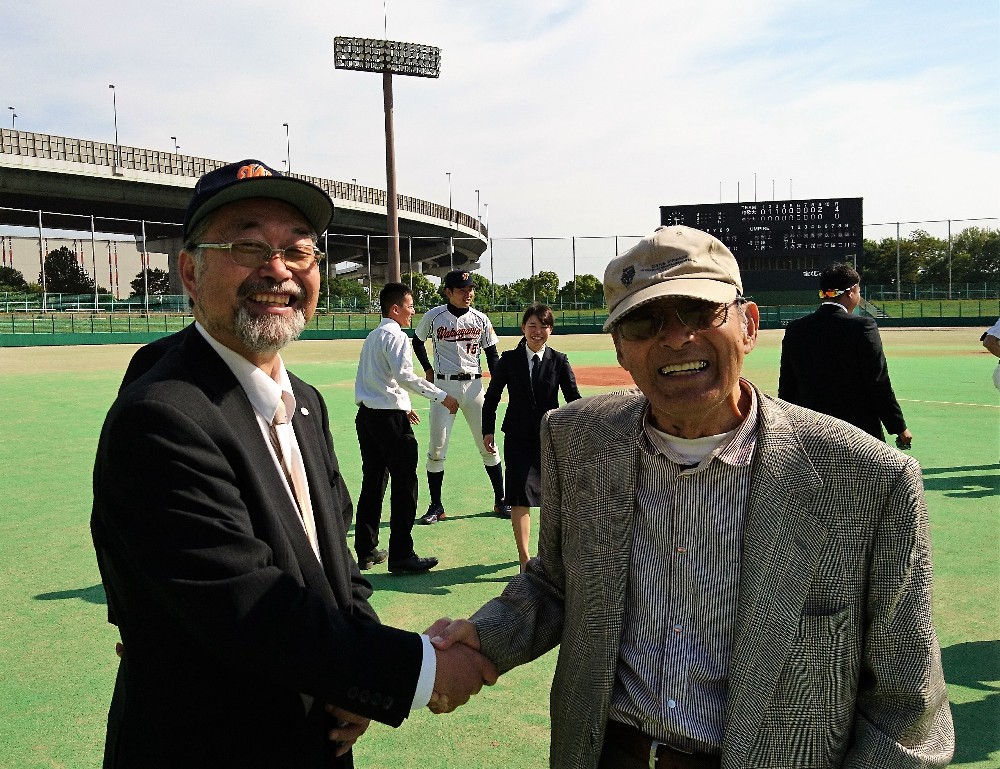 優勝決定後、和歌山大・竹林明野球部長（左）と握手を交わす和歌山大野球部ＯＢ会「和球会」相談役の神前孝之さん