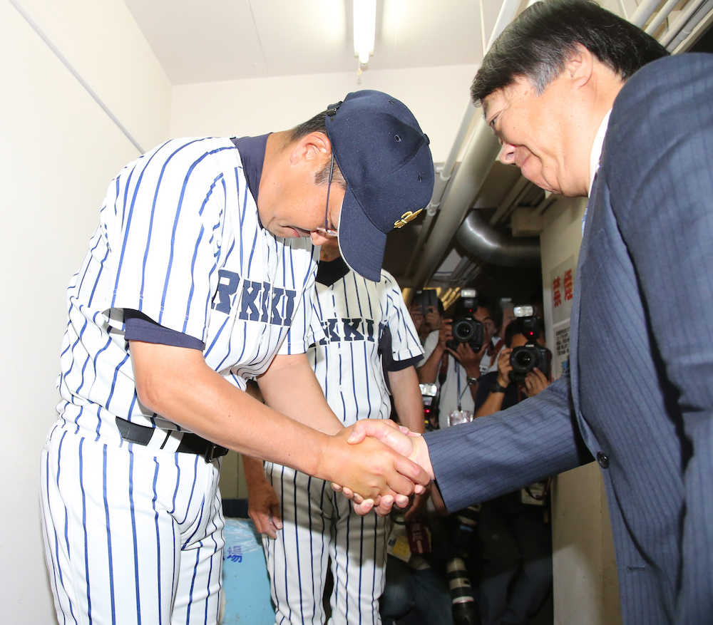 慶大の敗戦を記者席で見届けた立大・溝口監督（左）は前田部長と握手する