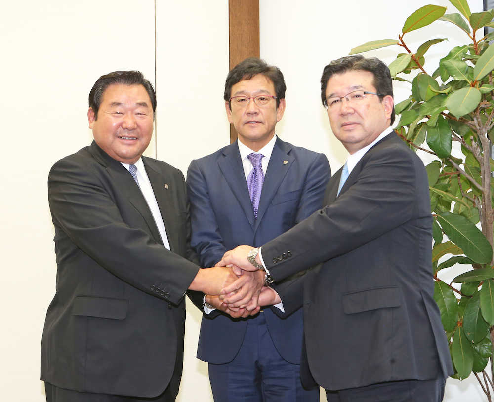 握手を交わす（左から）竹田球団社長、栗山監督、末沢オーナー