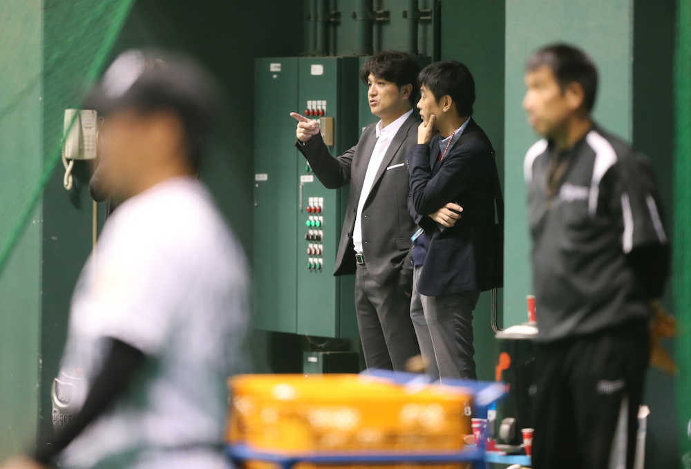 室内練習場で阪神の練習を見つめる巨人・高橋監督（中央）