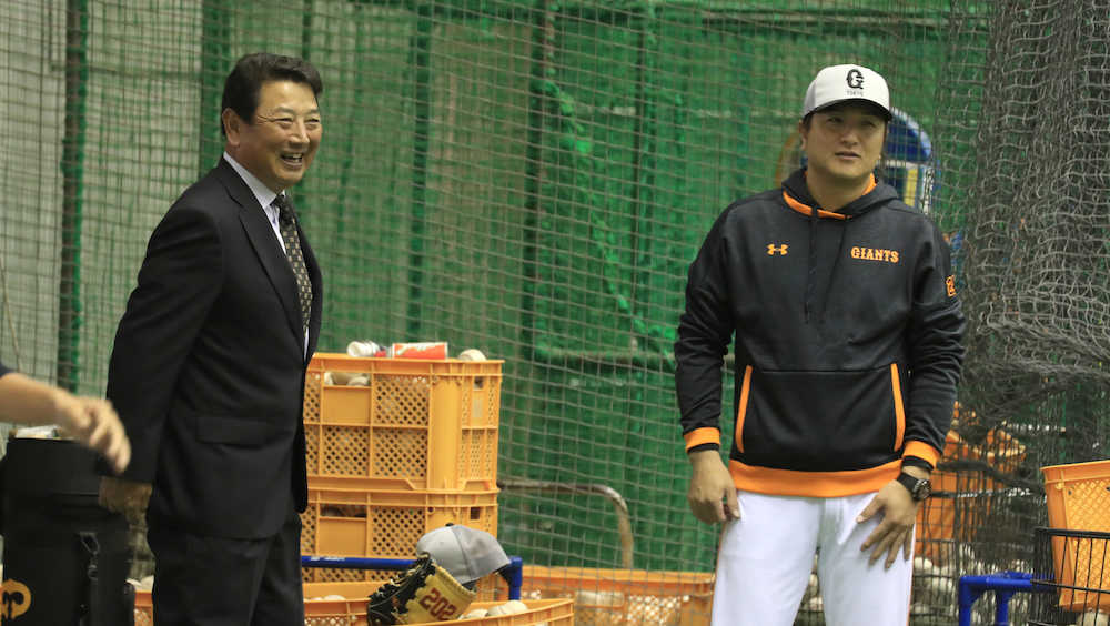 高橋監督（右）と笑顔で練習を見守る吉村打撃総合コーチ　　