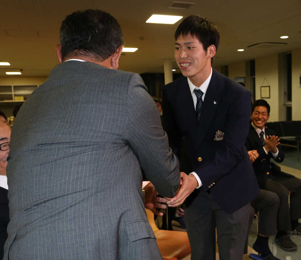 善波監督（左）と握手を交わす明大・斉藤