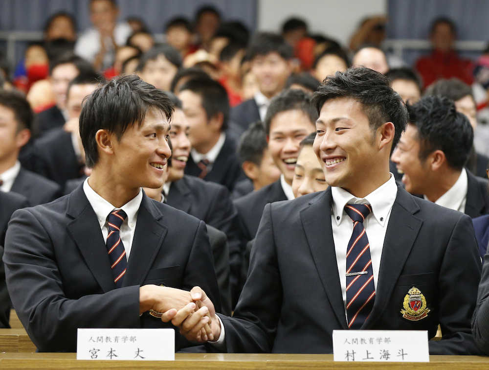 笑顔で握手を交わすヤクルト６位・宮本（左）と巨人７位・村上海