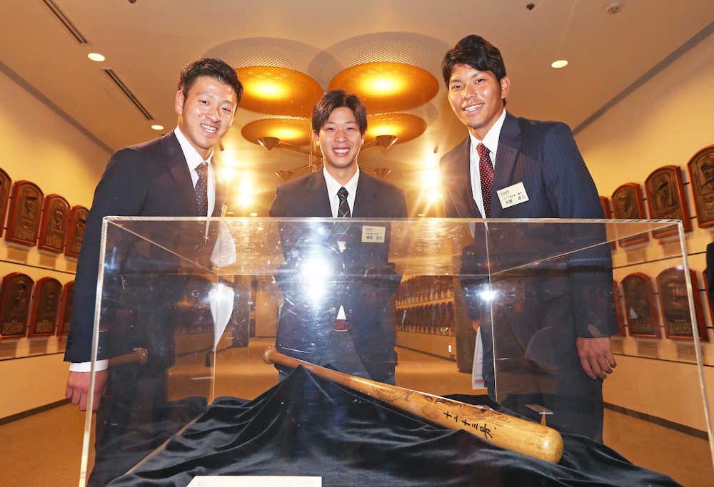 長嶋茂雄氏が展覧試合で本塁打を打ったバットを見つめる（左から）岸田、鍬原、大城