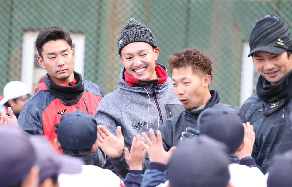 阪神・秋山（中央）は地元・愛媛の野球教室でヤクルト・平井（左）、鵜久森（右）、西武・熊代（右から２人目）らと笑顔で球児とハイタッチ