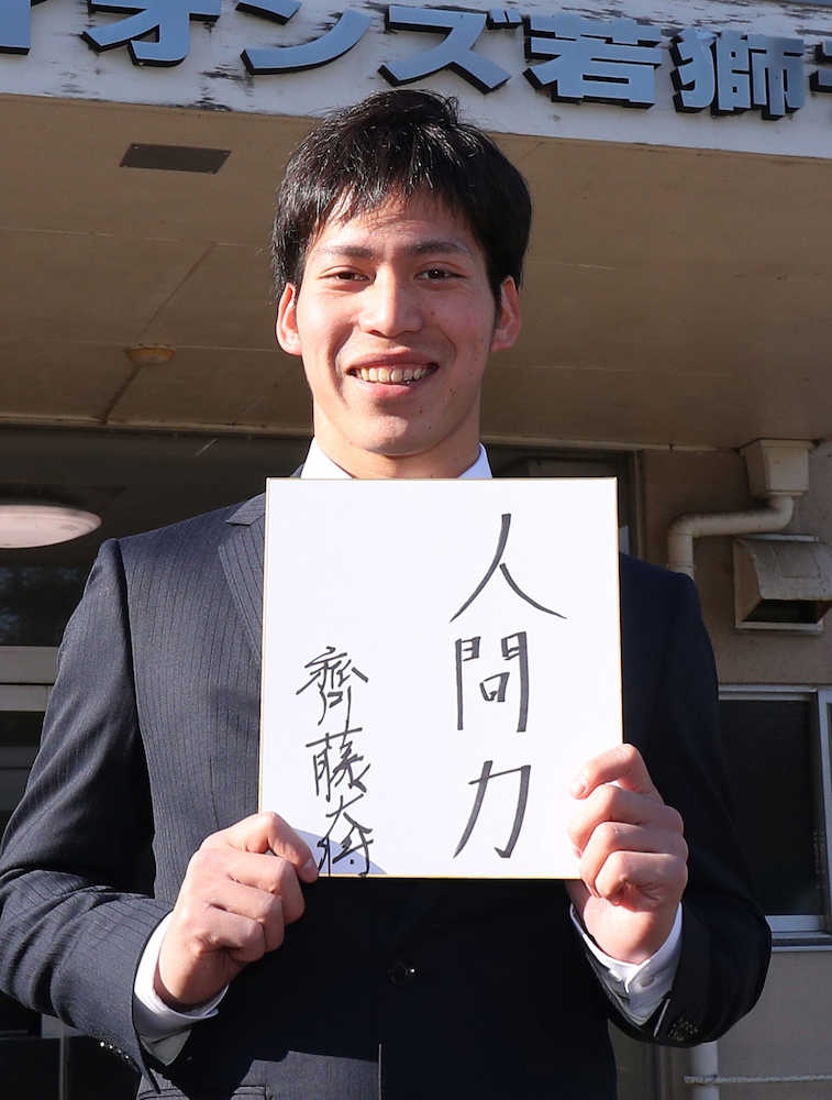 「人間力」と書いたサイン色紙を持ち笑顔の西武・斉藤大