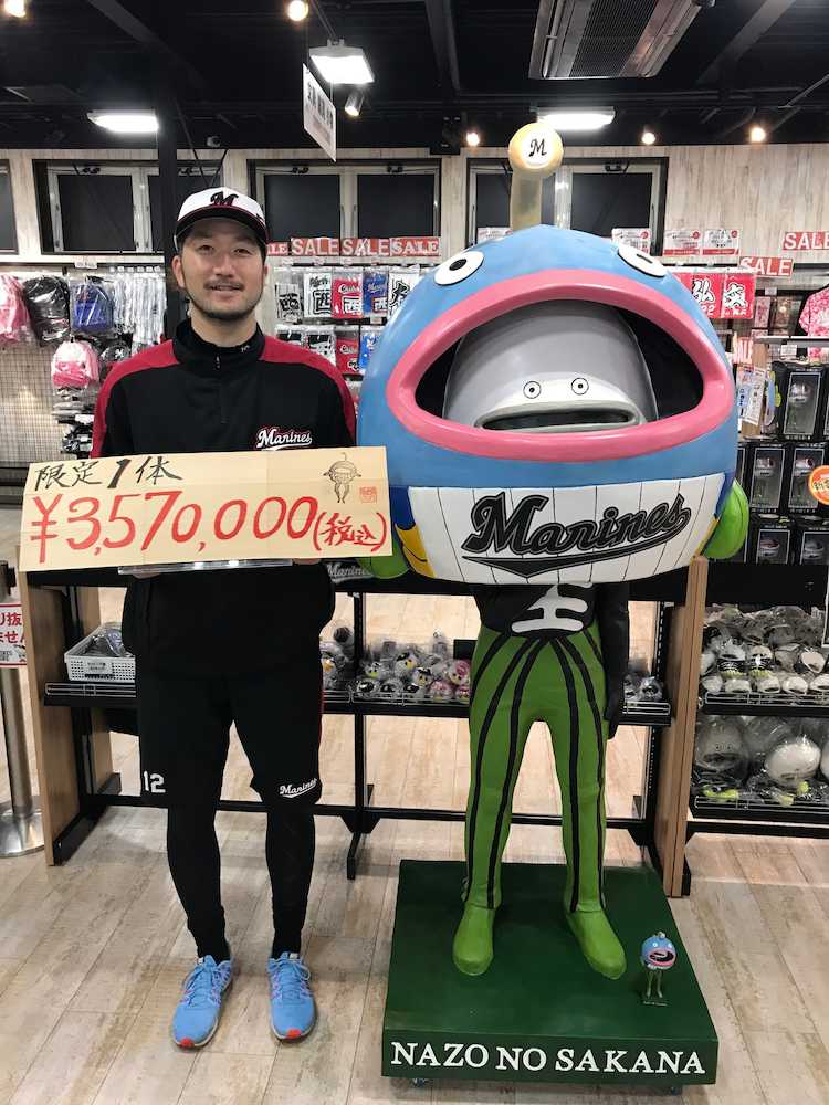 ３５７万円で売り出されるロッテの人気キャラクター「謎の魚」の等身大ＢＩＧボブルヘッド人形と値札を持つ石川