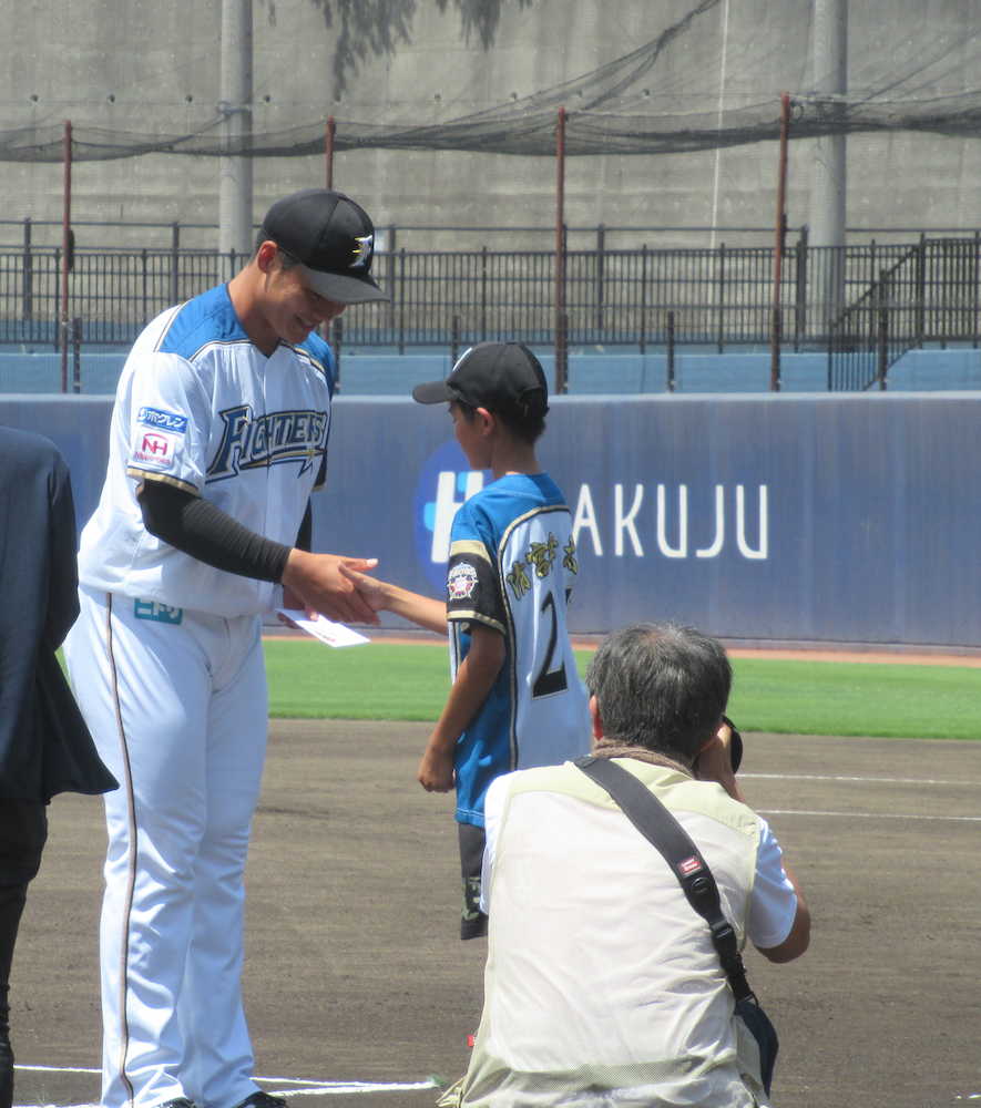 ＜日・ヤ＞試合前に表彰され、少年と握手する日本ハム・清宮
