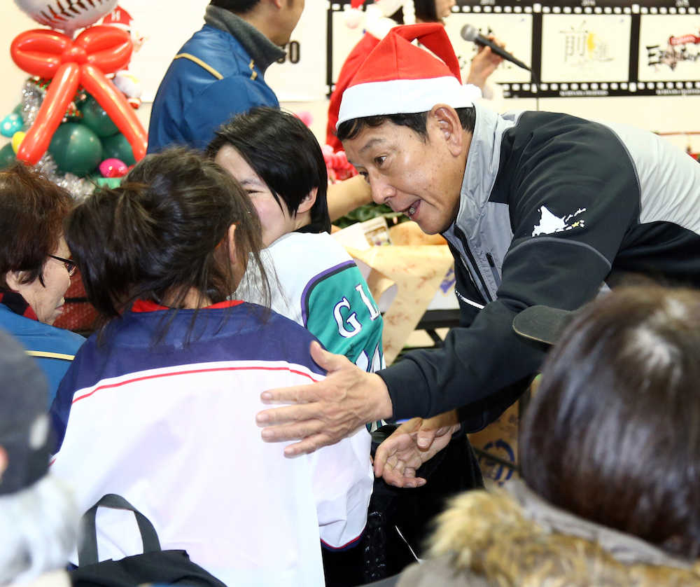 イベントに参加した栗山監督は抽選会で当たった子供にプレゼントを渡す（撮影・高橋茂夫）