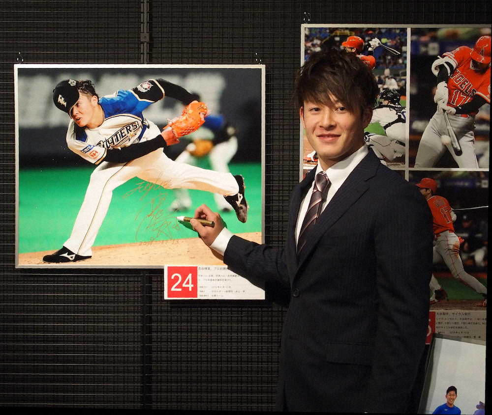 「野球報道写真展2019」のオープニング見学会に参加し、デビュー戦で力投する自らの写真にサインを入れた日本ハム・吉田輝