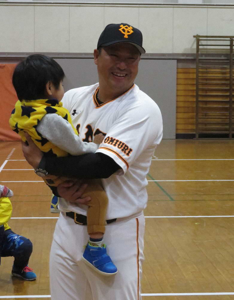 千葉県立千葉盲学校を訪問し、子供を抱き上げて笑顔を見せる巨人・村田2軍野手総合コーチ