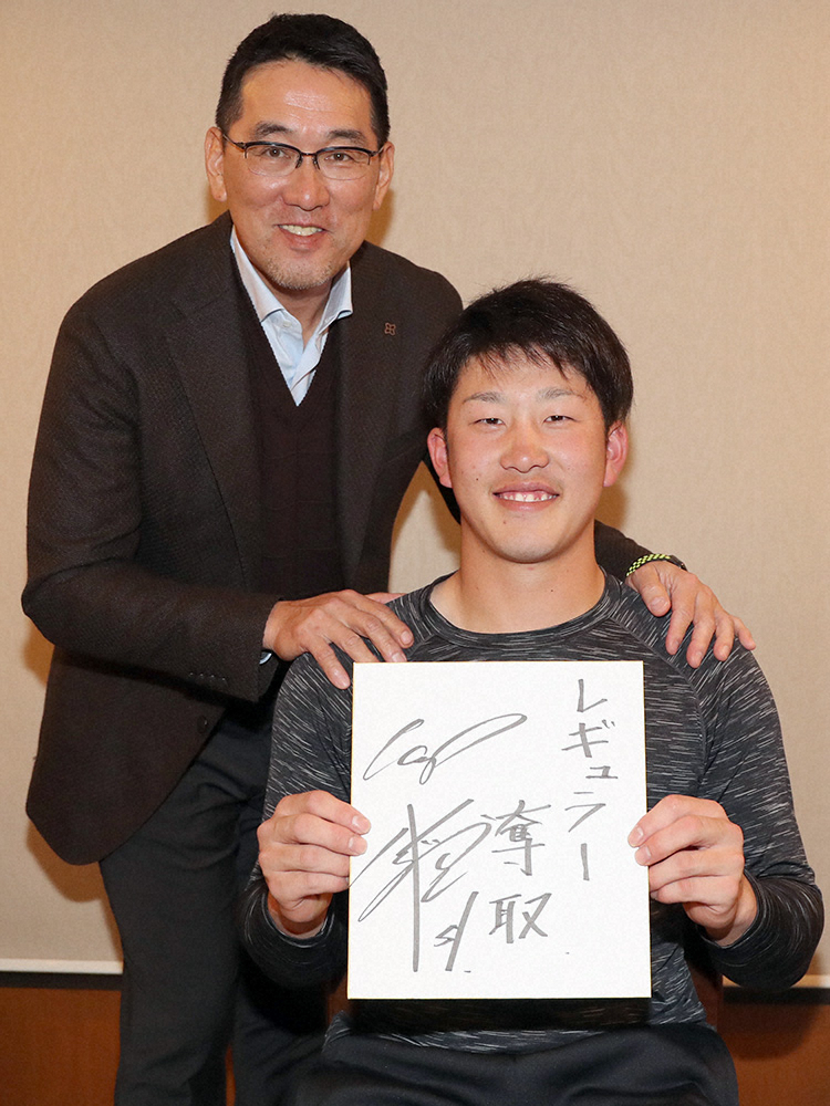 本紙評論家の野村謙二郎氏（左）の激励を受け、今季の抱負を書いた色紙を手にする広島・小園（撮影・奥　調）