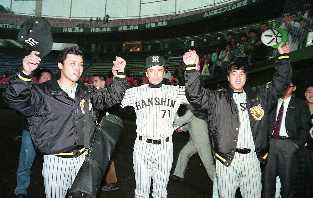 90年4月7日、広島に勝ち2本塁打の岡田（左）、完封の中西（右）の腕をあげる阪神・中村監督