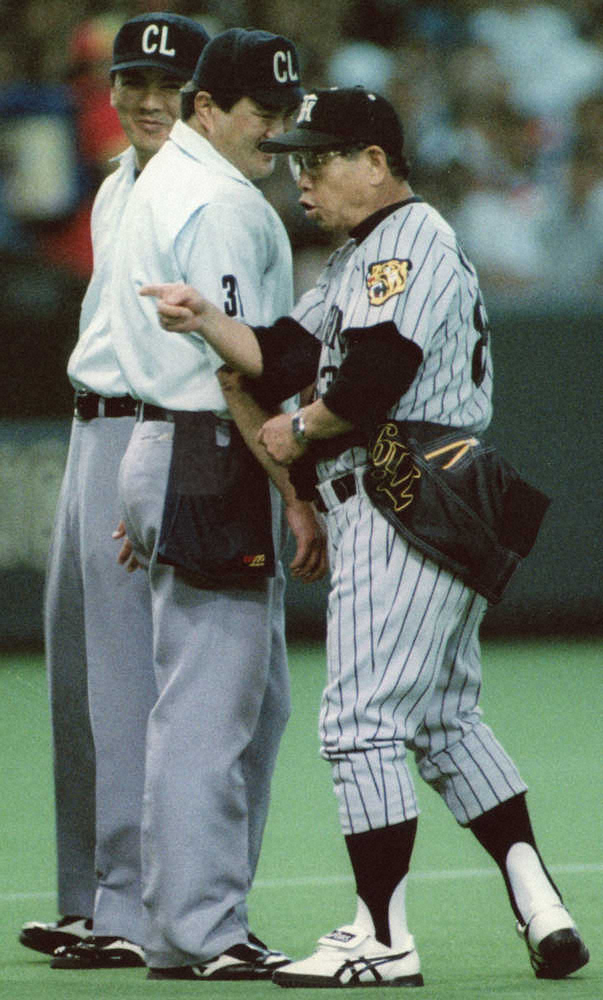 97年5月1日、巨人戦でウインドブレーカーを腰に巻いて抗議する吉田監督（右）と、その姿に笑いをこらえる渡田球審（中央）と友寄塁審