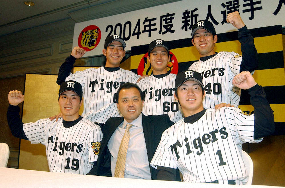 03年12月8日、阪神の新入団会見で岡田監督（前列中央）は自由枠獲得した鳥谷（前列右）らとともにポーズを決める