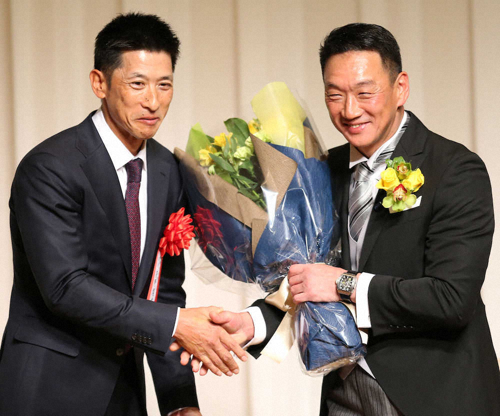 18年12月11日、金本氏（右）の野球殿堂入りを祝う会で矢野監督（左）から花束を受け取る