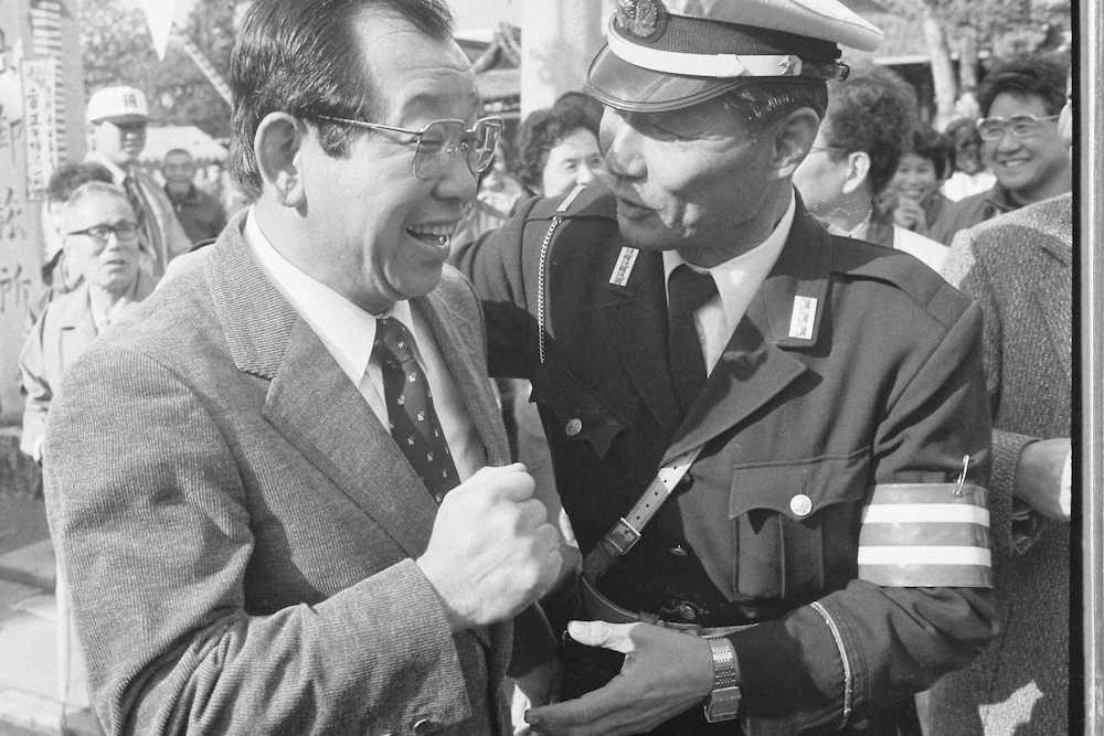 85年12月、生まれ育った北野神社御旅所で行われた吉田監督歓迎会で幼友達の警察官に出会い大喜びの吉田監督（左）