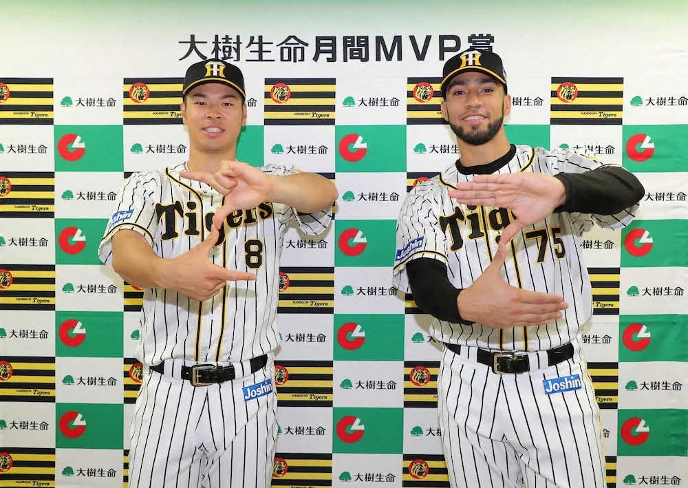 月間MVPを受賞しZポーズを決める佐藤輝（左）とスアレス