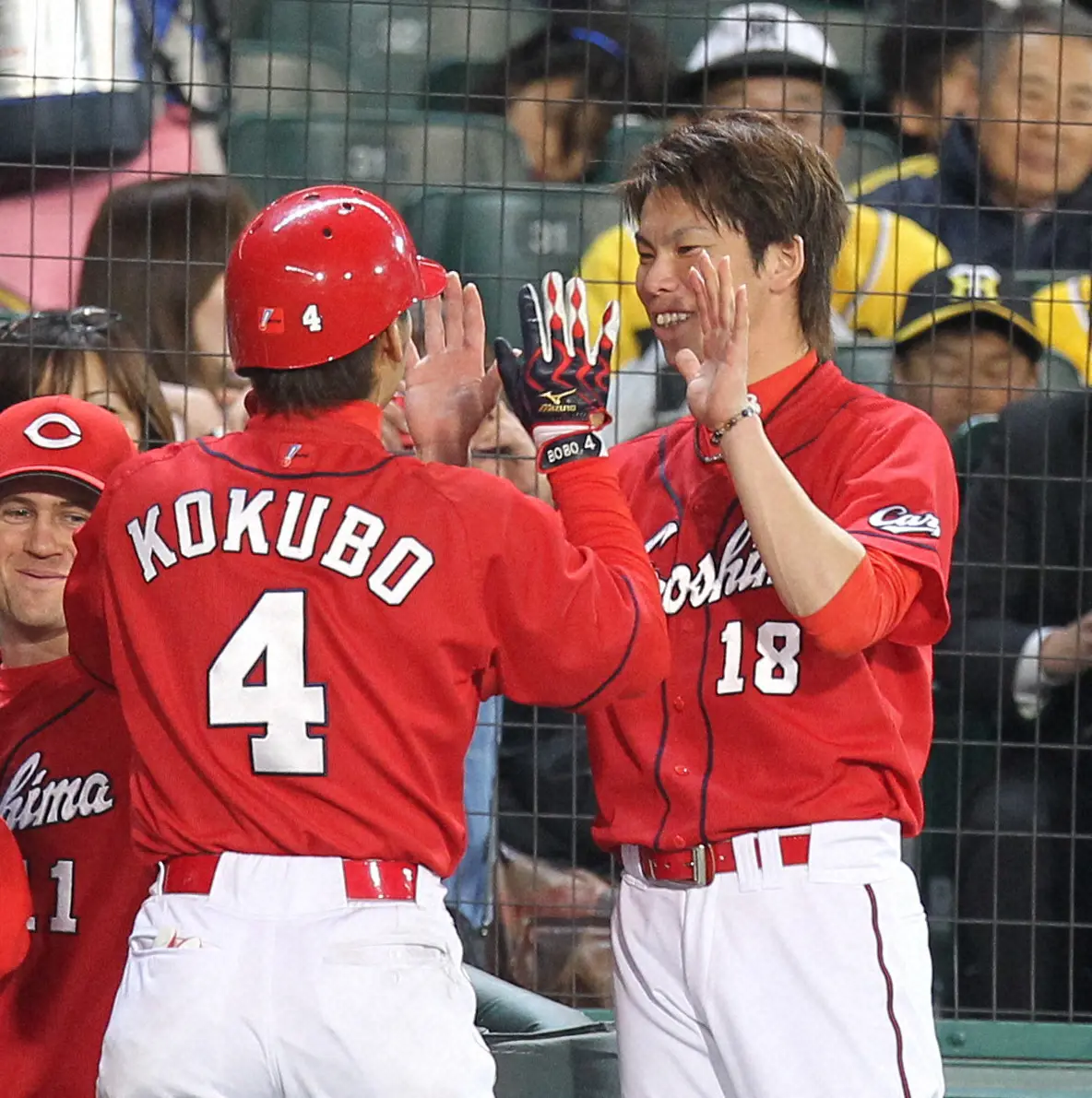 本塁打を放った広島・小窪哲也内野手（中央）を笑顔で迎える前田健太投手（右）　（2010年撮影）
