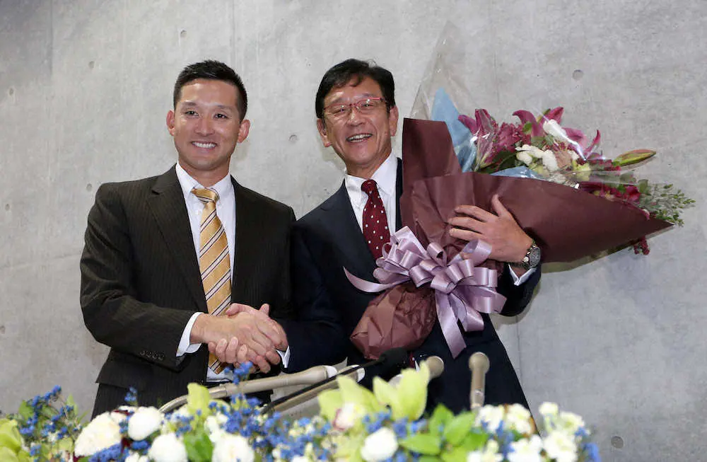 退任会見のサプライズで杉谷（左）から花束が贈られ笑顔で写真に納まる栗山監督（撮影・高橋茂夫）