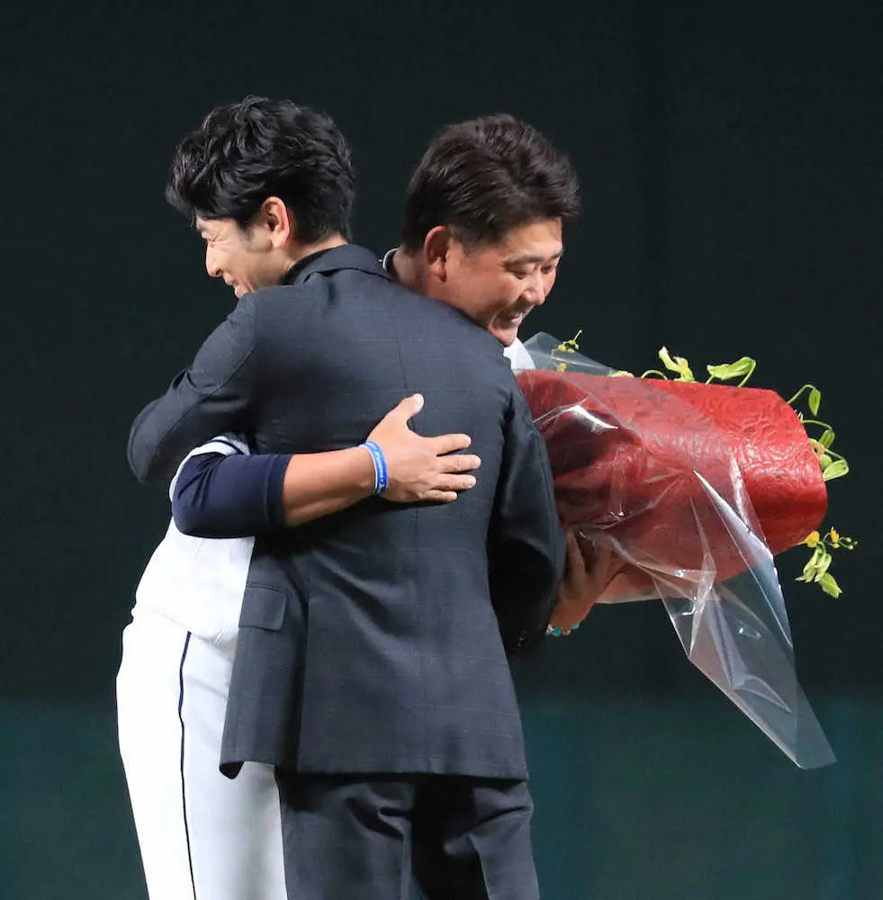 妻夫木聡（手前）から花束を受け取り抱き合う松坂