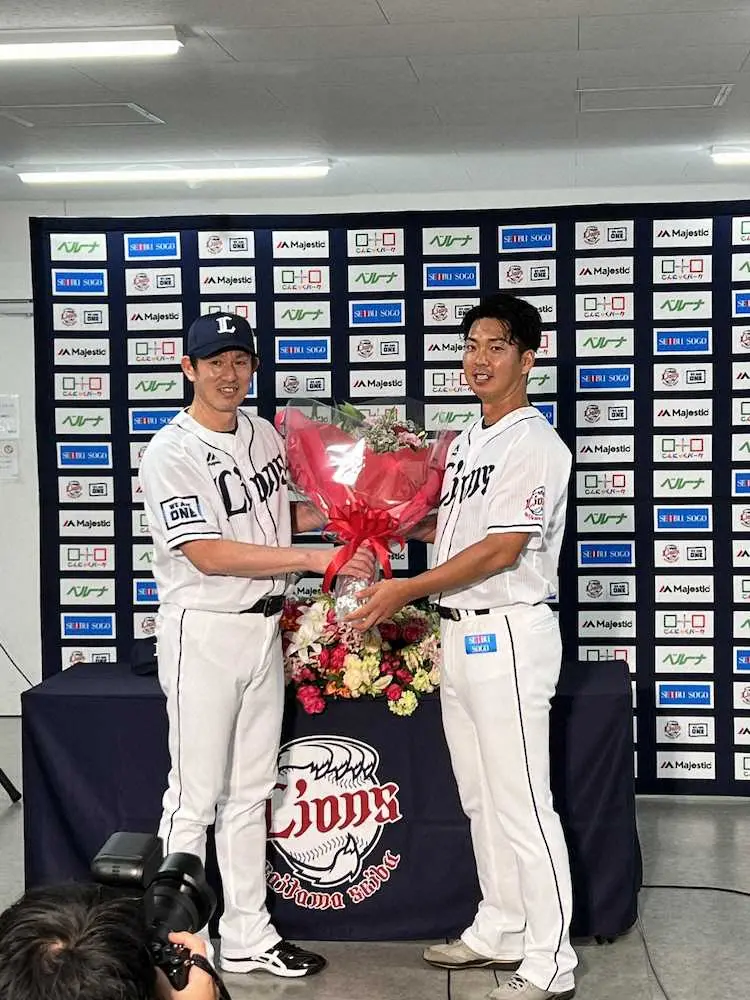 西武・十亀（右）は引退会見で、豊田投手コーチから花束を渡される