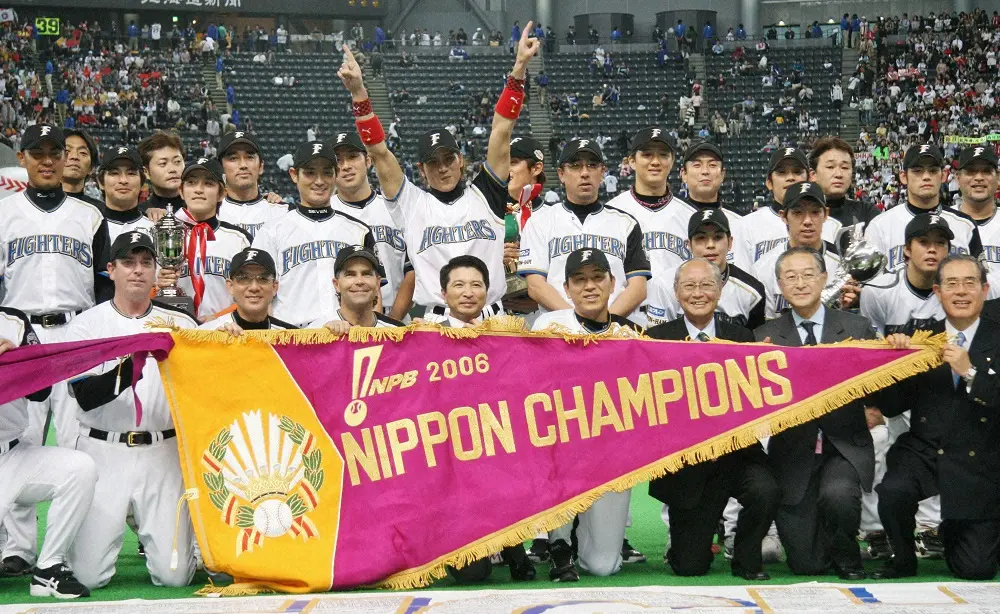 2006年、日本一のチャンピオンフラッグを手に記念撮影するヒルマン監督（前列左から３人目）と後方で両手を挙げ喜ぶ新庄