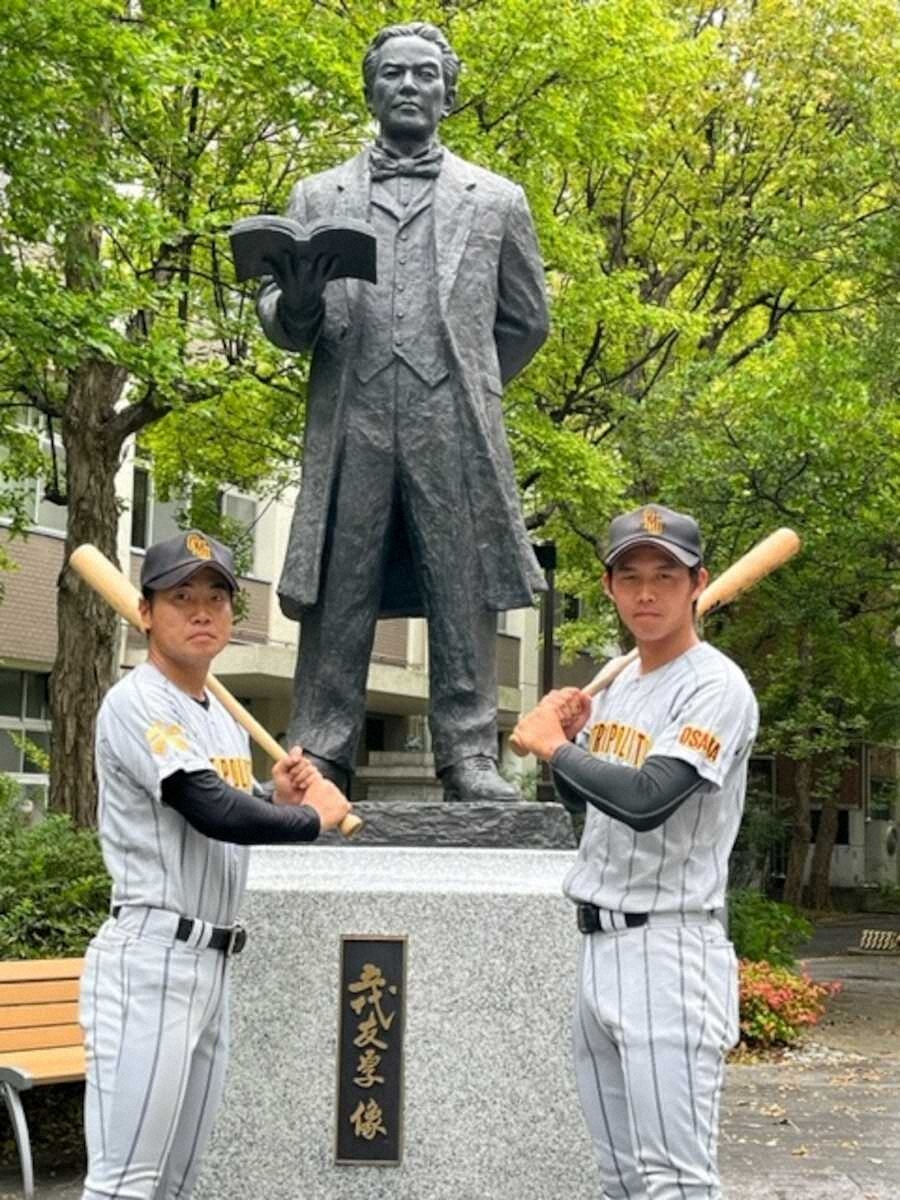 五代友厚像の前でリーグ3連覇への意欲を見せる大阪公立大の真銅（左）と大西優