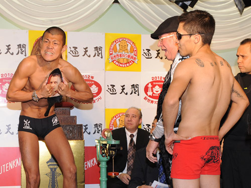 挑戦者・マシアスの顔写真つきフライパンを曲げる亀田興毅（左）