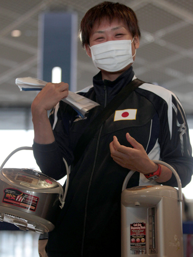 女子ボクシング世界選手権に出場する山崎静代は機内に持ち込む炊飯器と電気ポットを抱えて笑顔を見せる