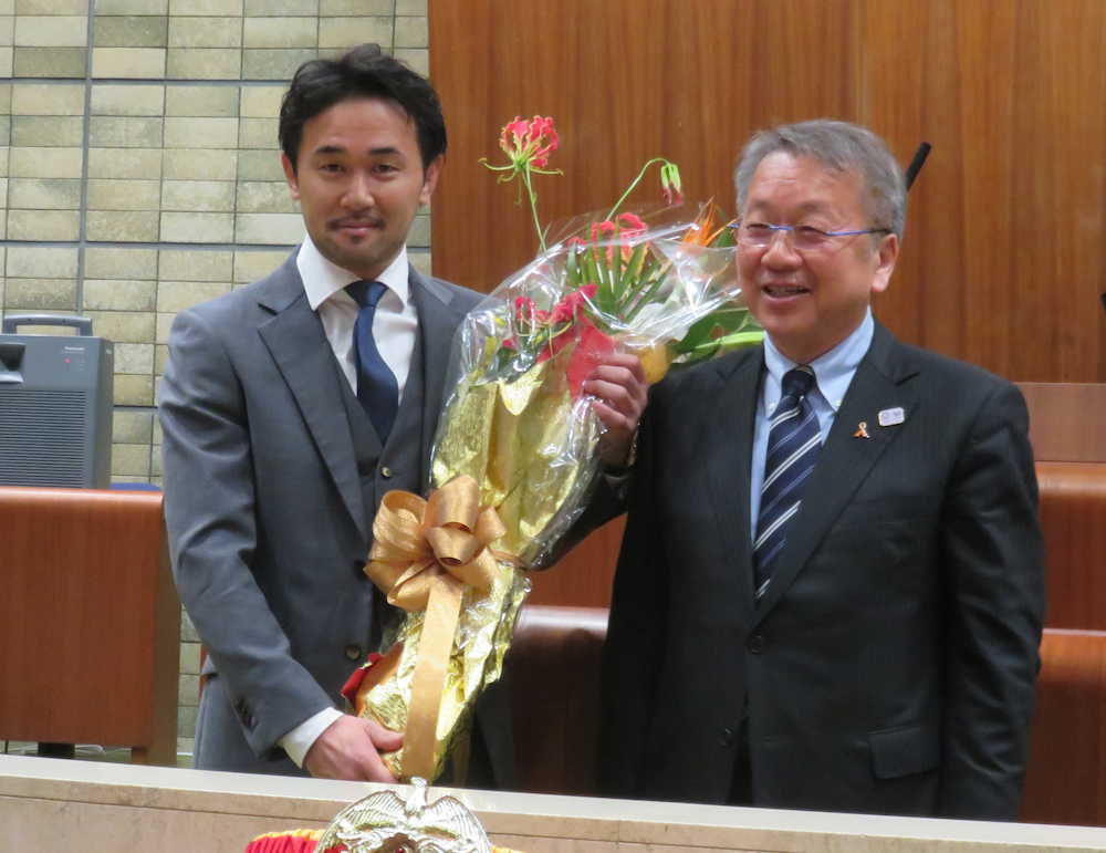 田中区長（右）から花束を渡されてねぎらわれた山中氏