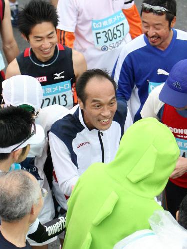 男子マラソン、ゴールした東国原英夫・宮崎県知事（中央）は周囲のランナーに囲まれる大人気ぶり