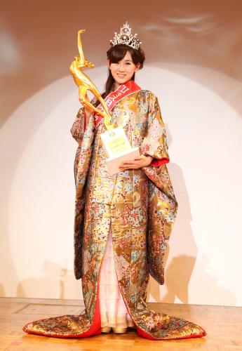 グランプリに輝いた谷中麻里衣さんは、笑顔でトロフィーを掲げる
