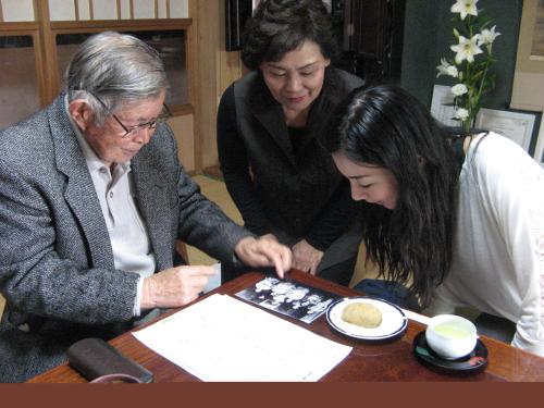 祖母・和嘉さんの１０代の頃の写真と大久保利通につながる家系図を見せられ、思わず身を乗り出す植村花菜（左から伊勢達一さん、伊勢エツ子さん）　