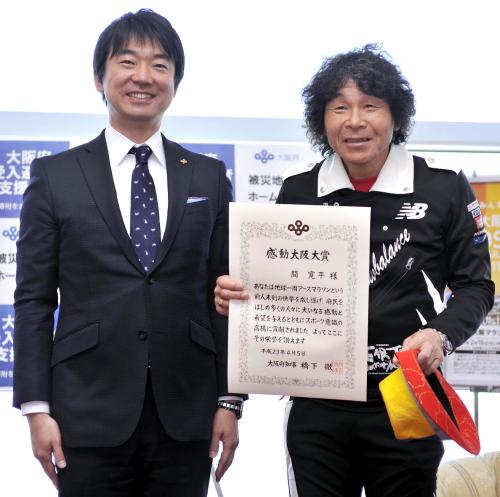 「アースマラソン」で地球一周を達成し、大阪府の橋下知事（左）から感動大阪大賞を授与された間寛平